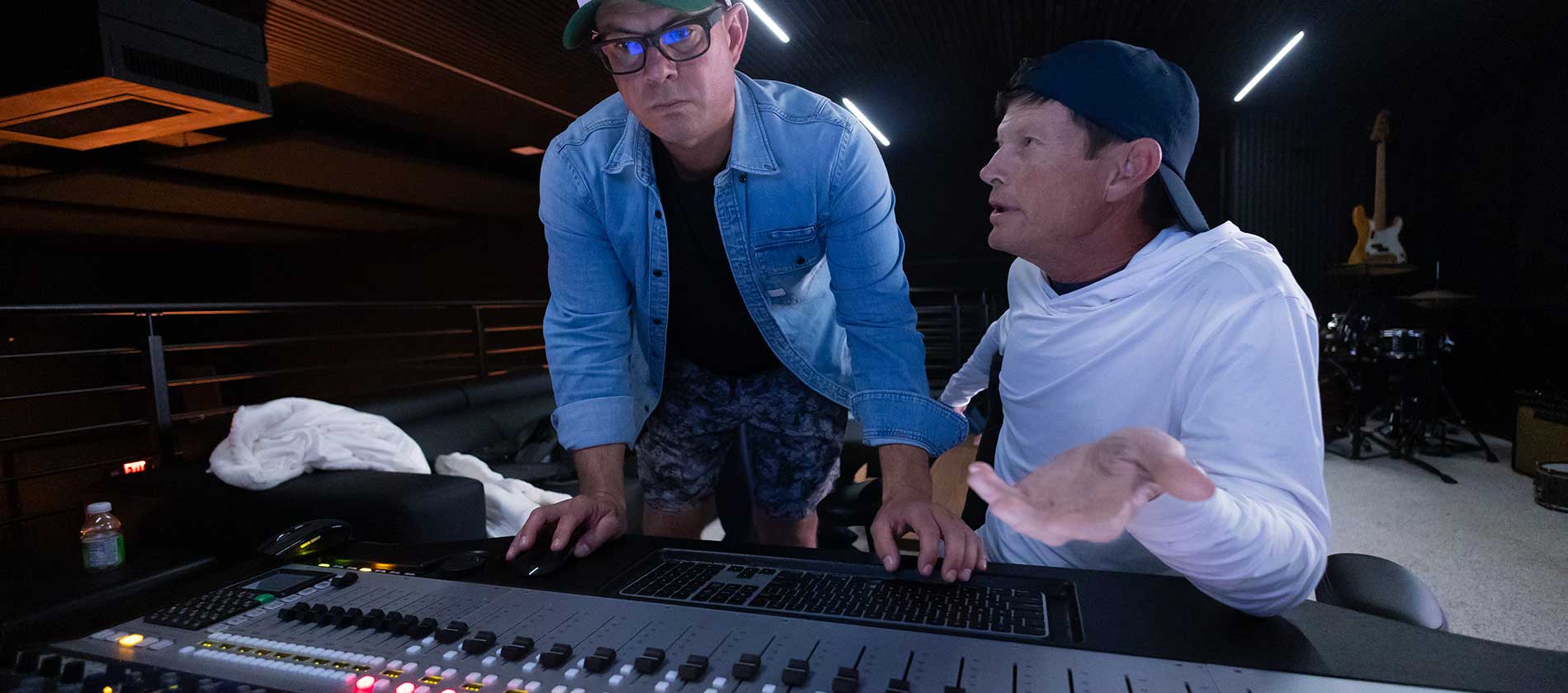 Two people working at the mixing console in the control room