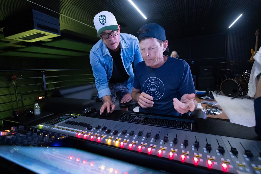 Two people working at the mixing console in the control room